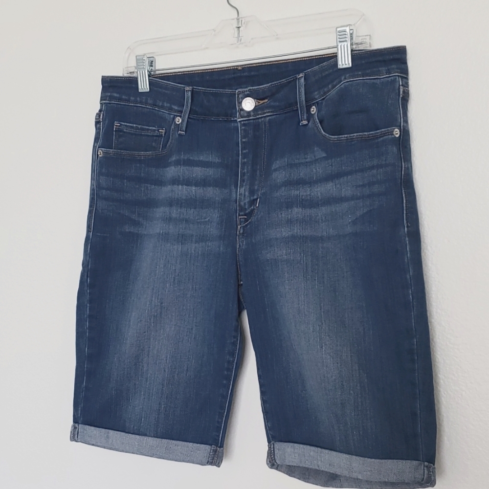 Levi's mid rise Jean shorts med wash light distressing sz 31 with 9 inch inseam